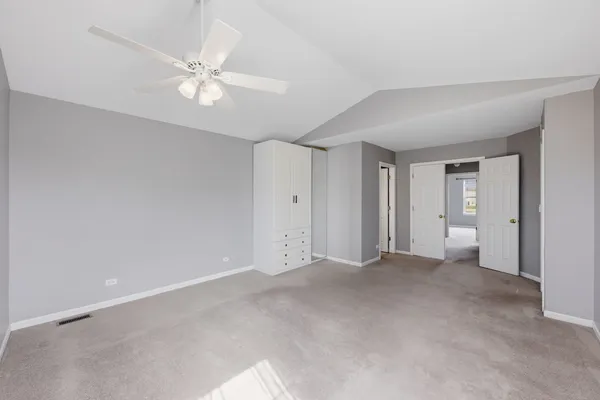 a view of an empty room with a chandelier fan