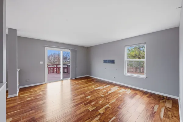 a view of an empty room with window and wooden floor