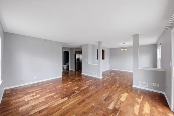 a view of empty room with wooden floor