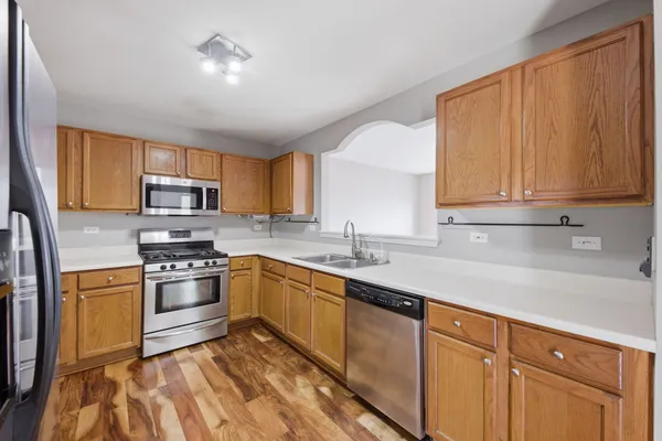 a kitchen with stainless steel appliances granite countertop a sink stove and refrigerator