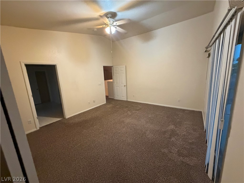 7629 Rory Court Las Vegas, NV 89129 - Photo 11 of 25 A spacious room features a vaulted ceiling and rich, dark brown carpeting.