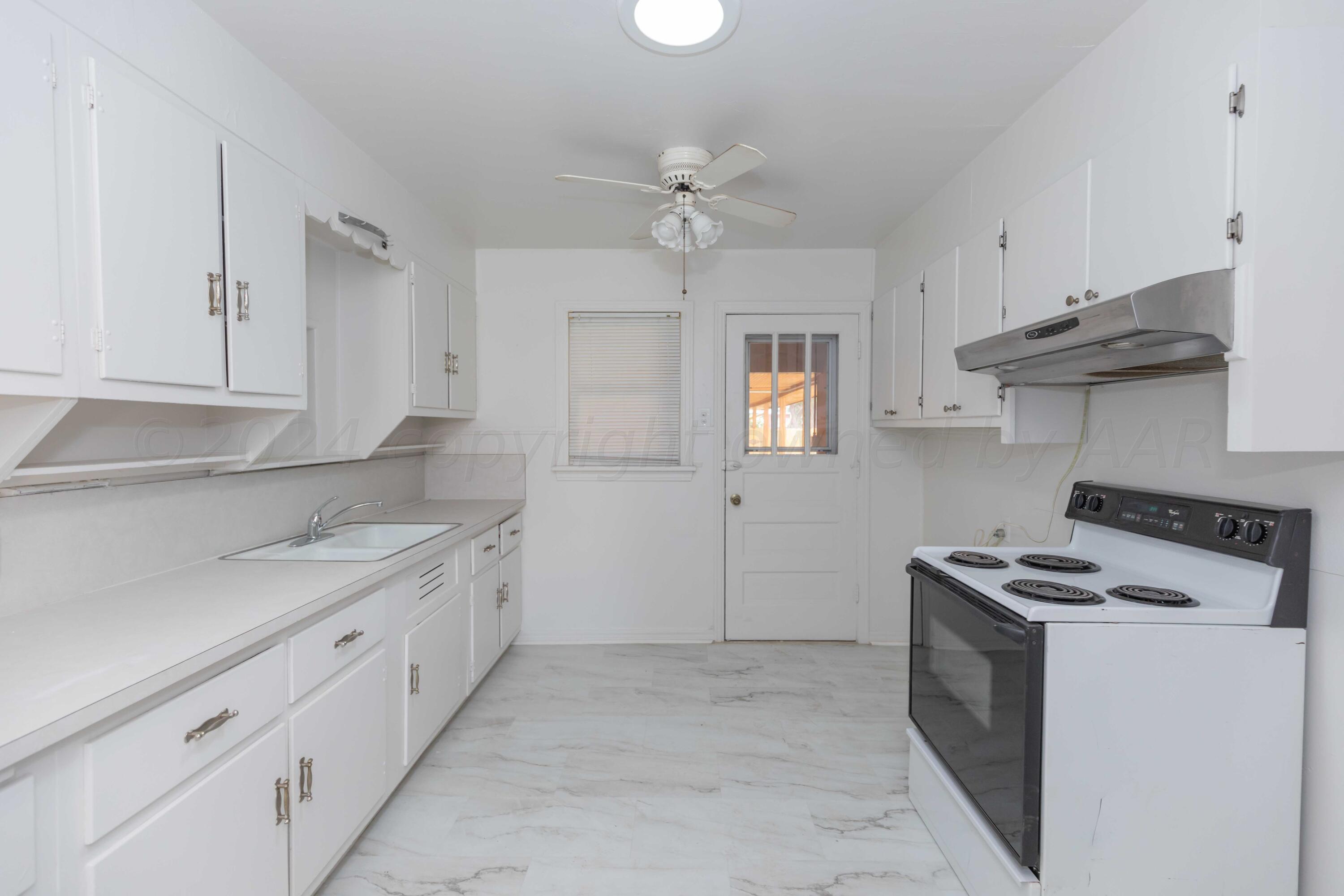 1613 South Travis Street Amarillo, TX 79102 - Photo 13 of 49 a kitchen with granite countertop a sink stove and cabinets
