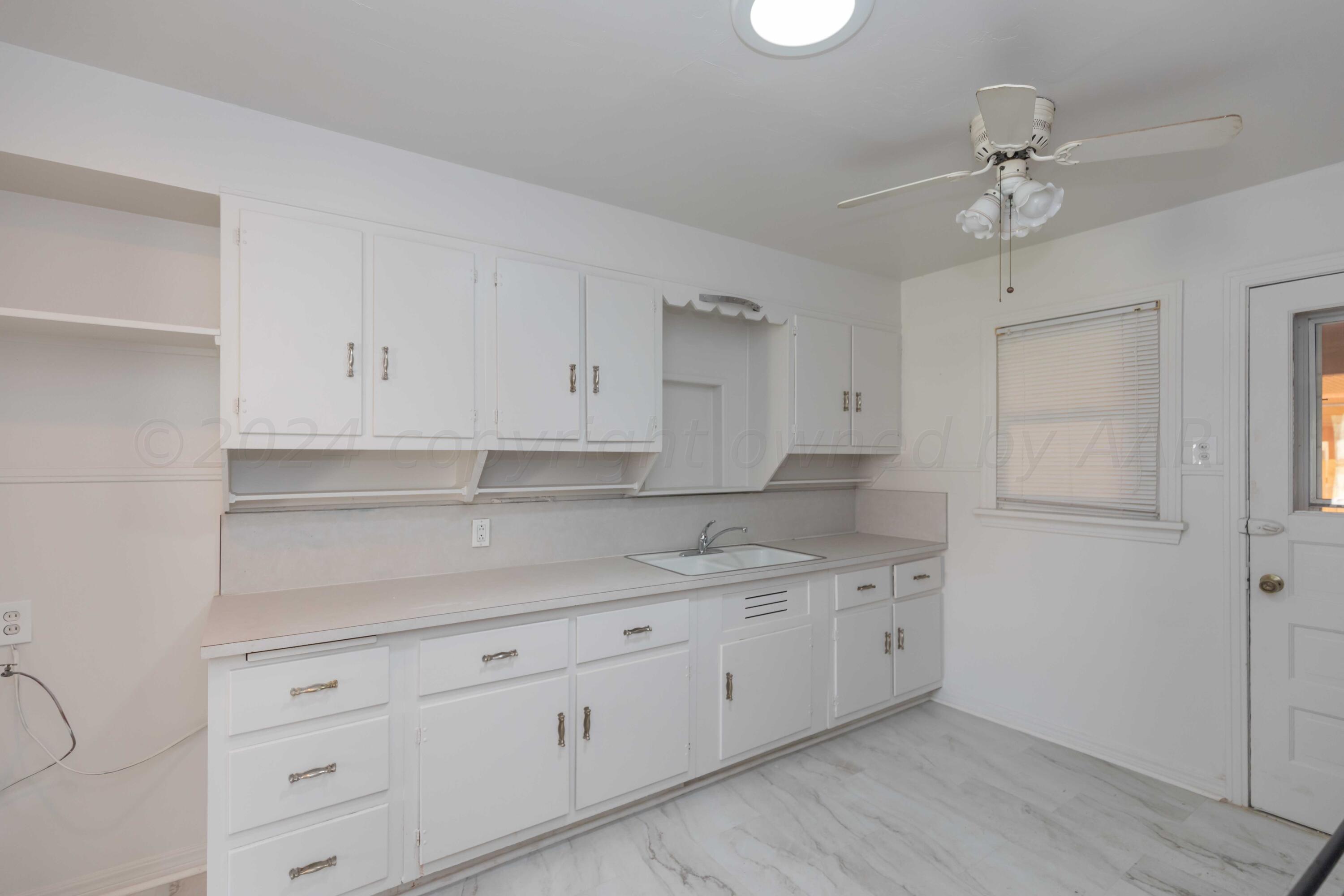 1613 South Travis Street Amarillo, TX 79102 - Photo 15 of 49 a kitchen with white cabinets and a sink