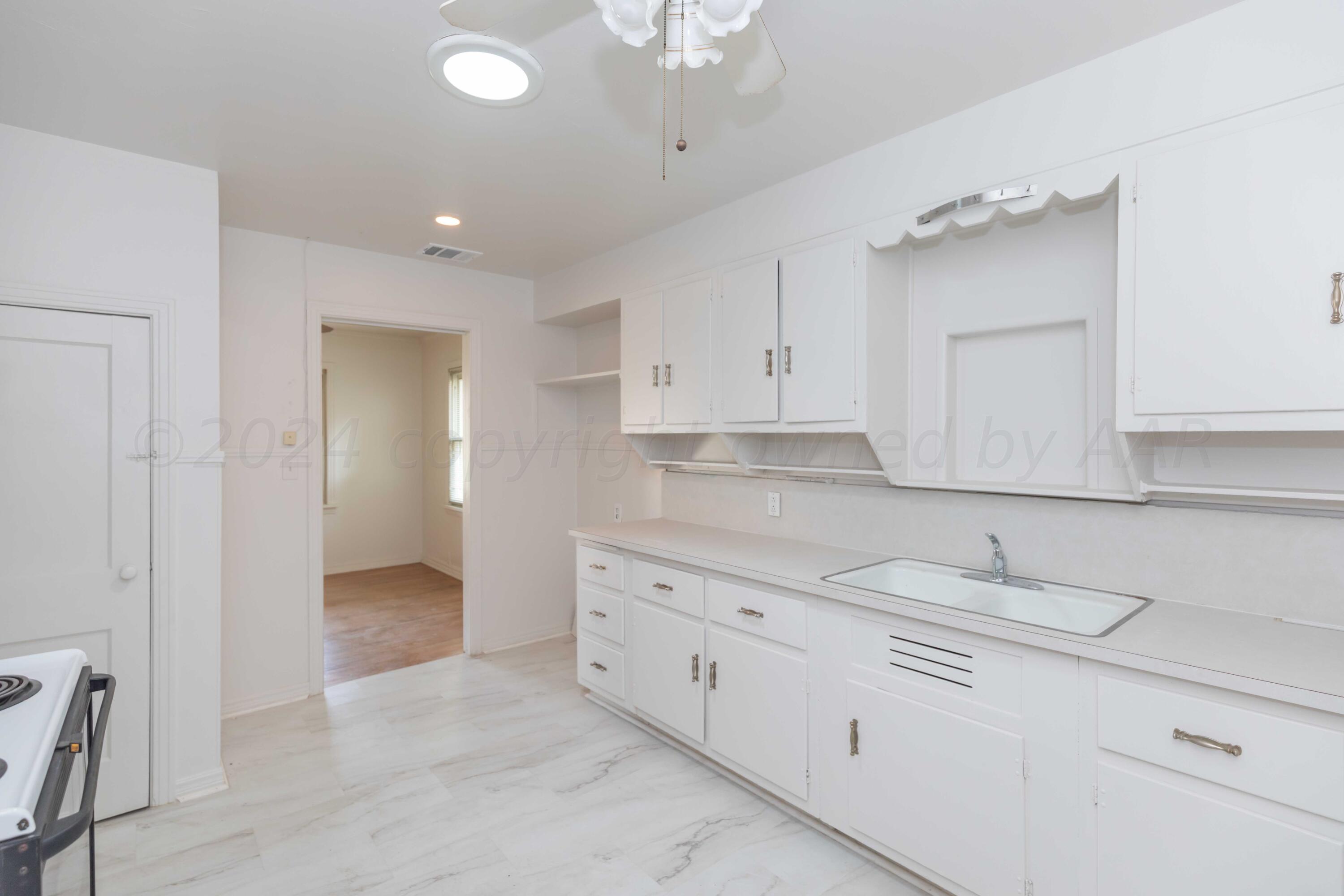 1613 South Travis Street Amarillo, TX 79102 - Photo 16 of 49 a kitchen with granite countertop white cabinets and white appliances