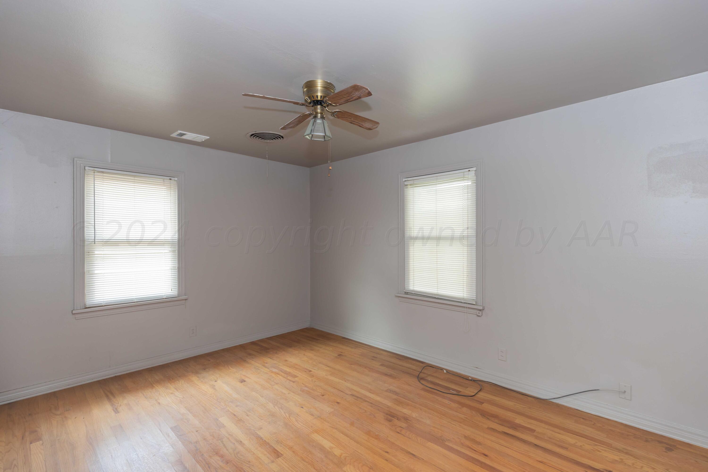 1613 South Travis Street Amarillo, TX 79102 - Photo 17 of 49 a view of empty room with wooden floor and fan