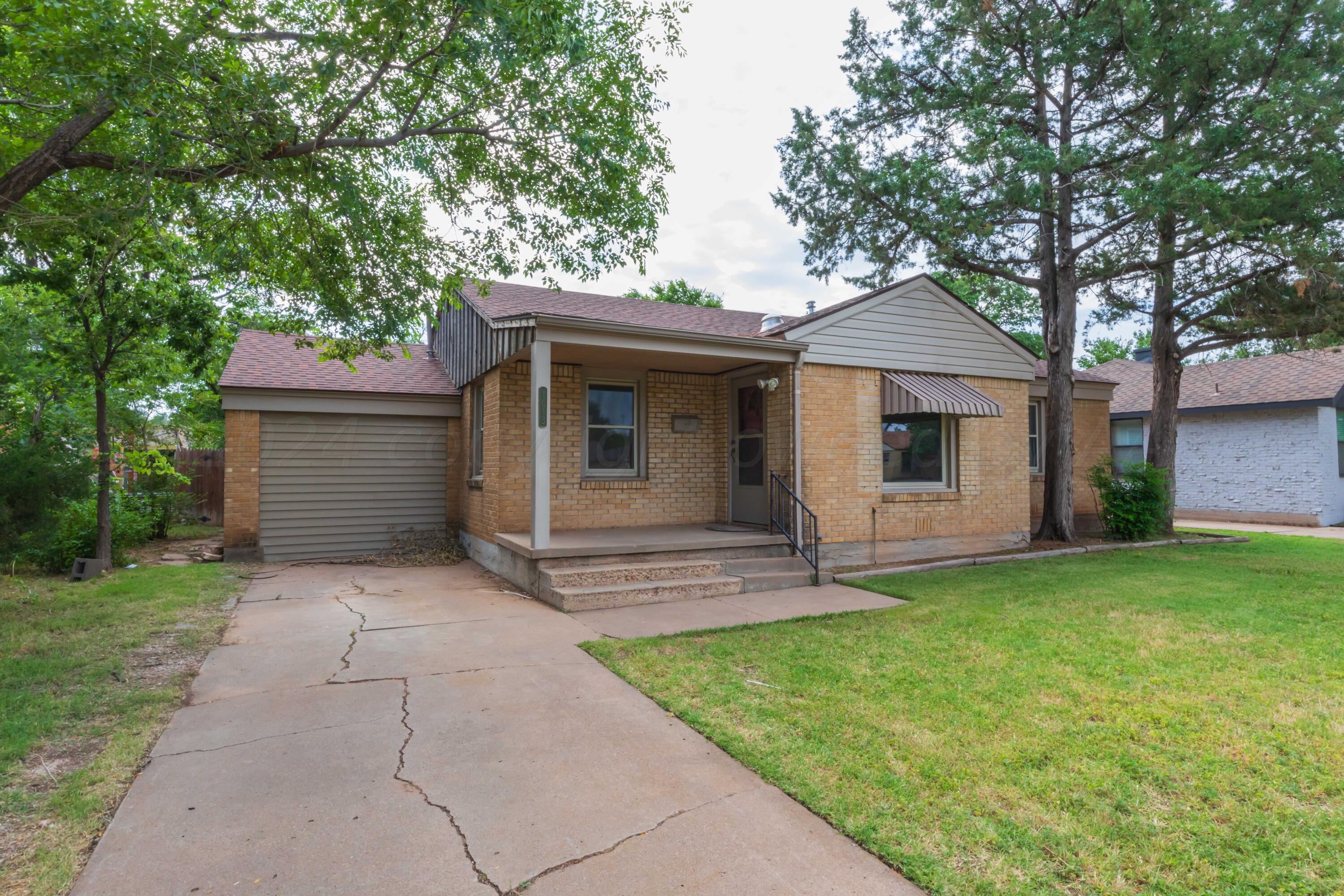 1613 South Travis Street Amarillo, TX 79102 - Photo 2 of 49 a front view of a house with a garden and yard