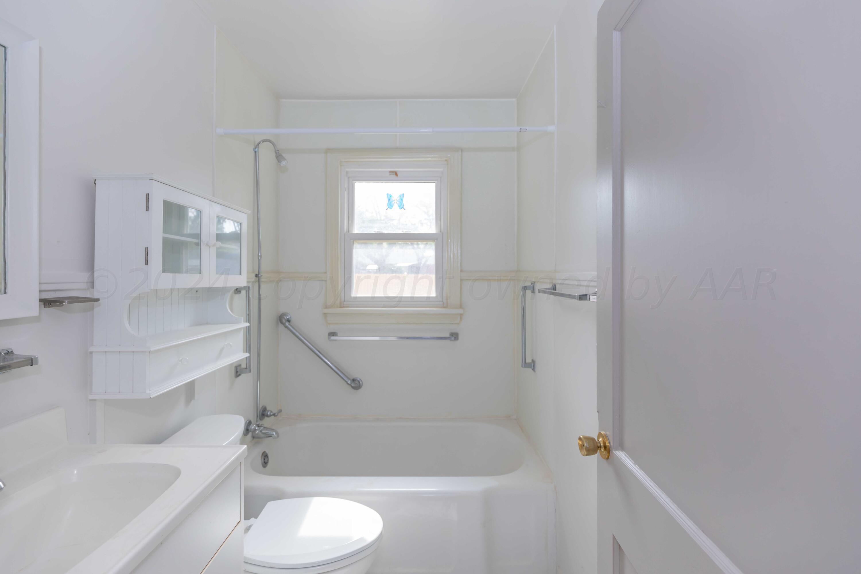 1613 South Travis Street Amarillo, TX 79102 - Photo 21 of 49 a bathroom with a granite countertop bathtub shower sink vanity and toilet