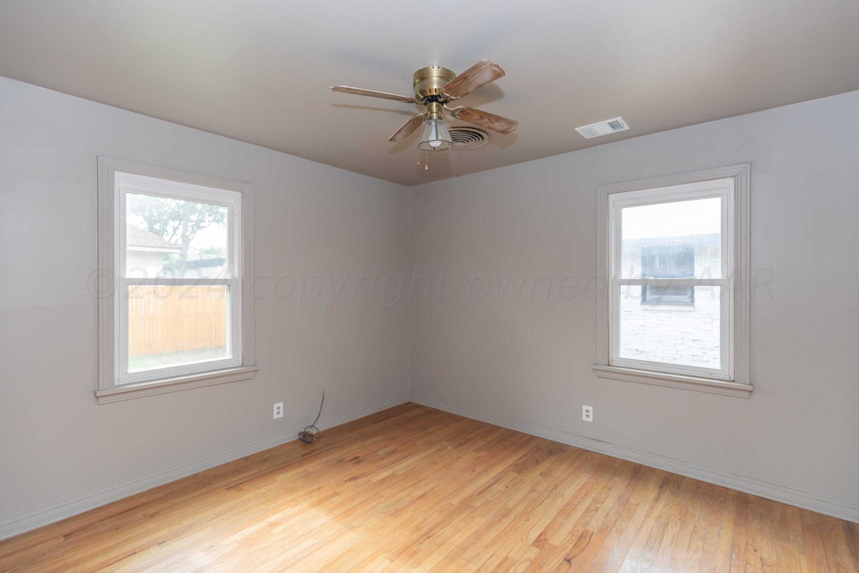 1613 South Travis Street Amarillo, TX 79102 - Photo 24 of 49 a view of an empty room with a window and wooden floor