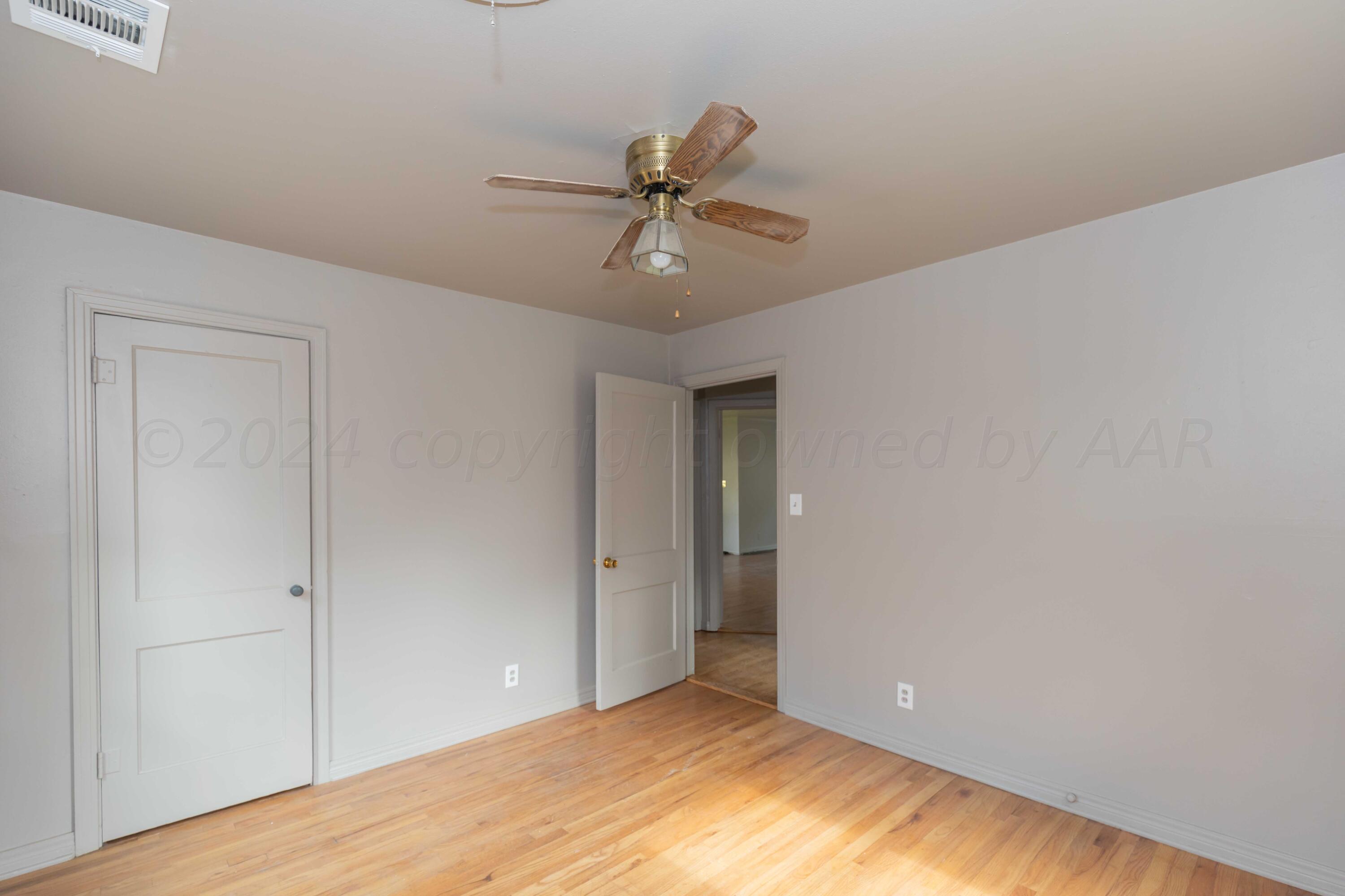 1613 South Travis Street Amarillo, TX 79102 - Photo 26 of 49 a view of a room with a ceiling fan and hardwood floor