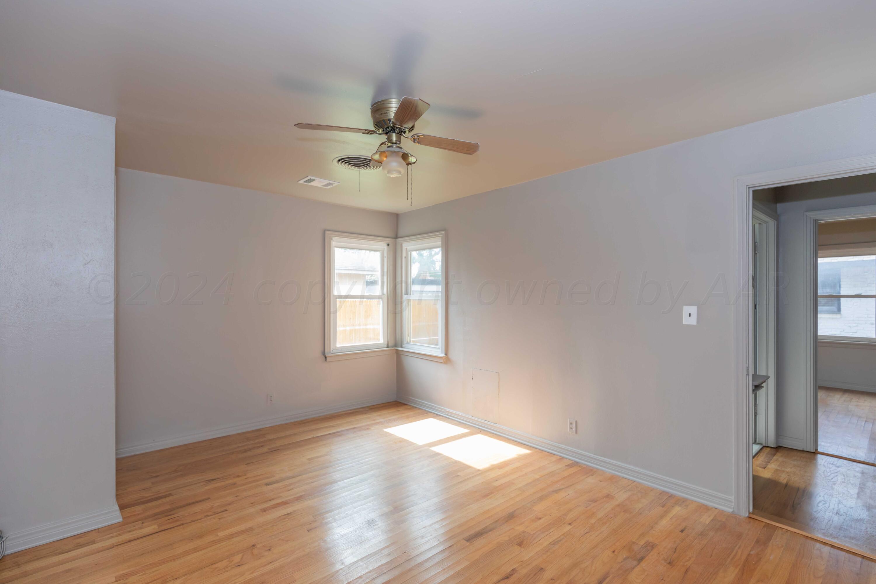 1613 South Travis Street Amarillo, TX 79102 - Photo 30 of 49 a view of empty room with wooden floor and fan