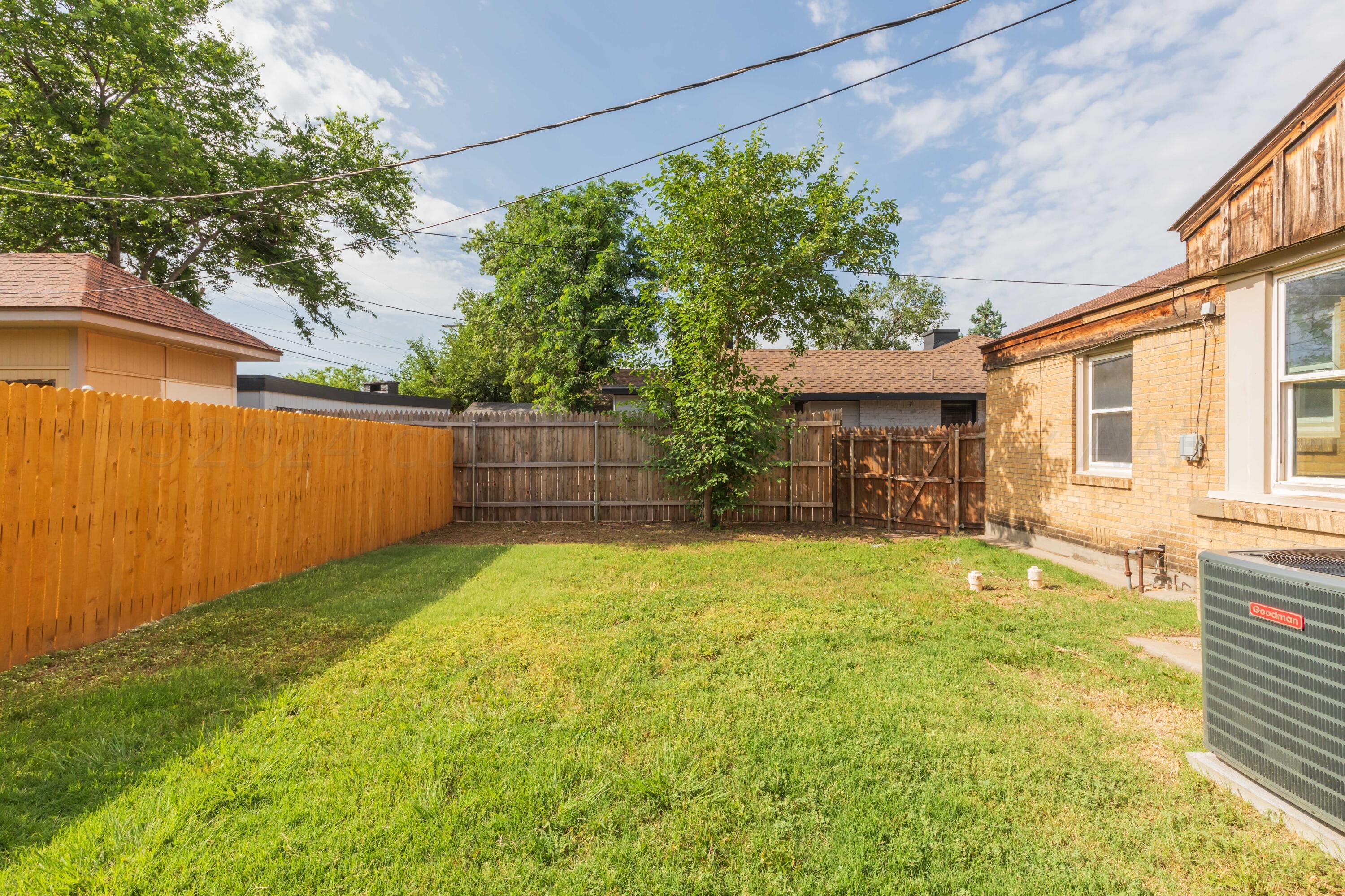 1613 South Travis Street Amarillo, TX 79102 - Photo 36 of 49 a view of a backyard with a garden and tree
