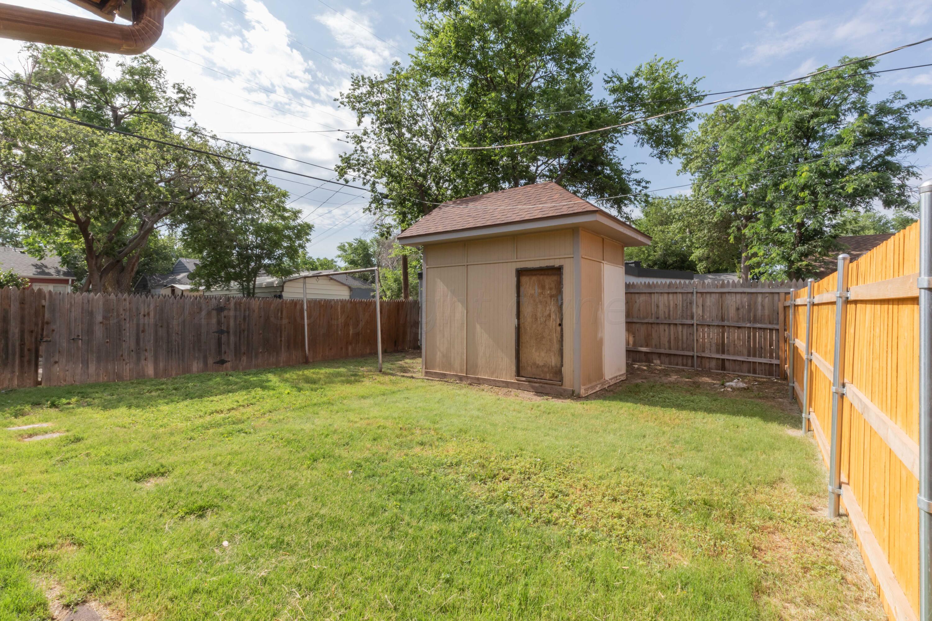 1613 South Travis Street Amarillo, TX 79102 - Photo 49 of 49 a view of a backyard with a small cabin and a chair