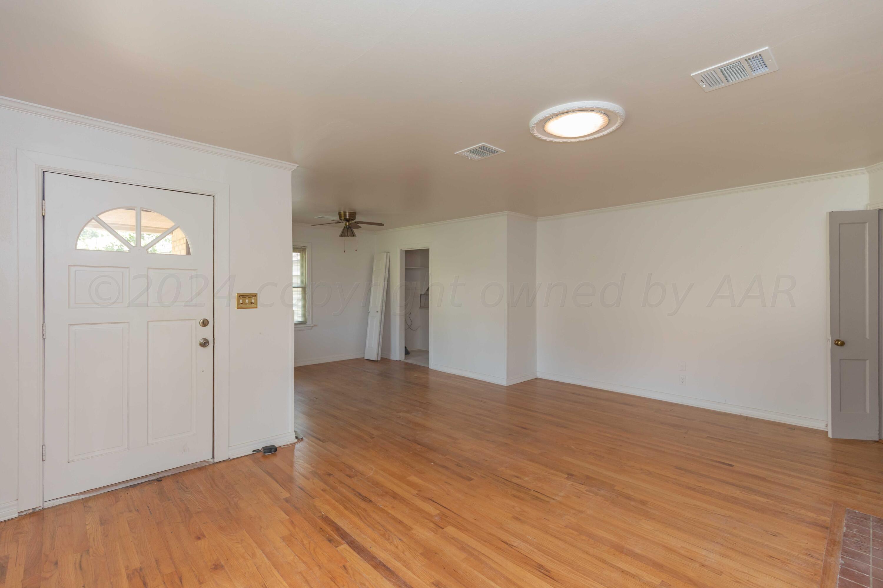 1613 South Travis Street Amarillo, TX 79102 - Photo 7 of 49 a view of an empty room with wooden floor and closet