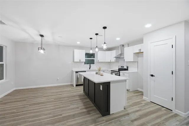 a kitchen with a sink stainless steel appliances and white cabinets
