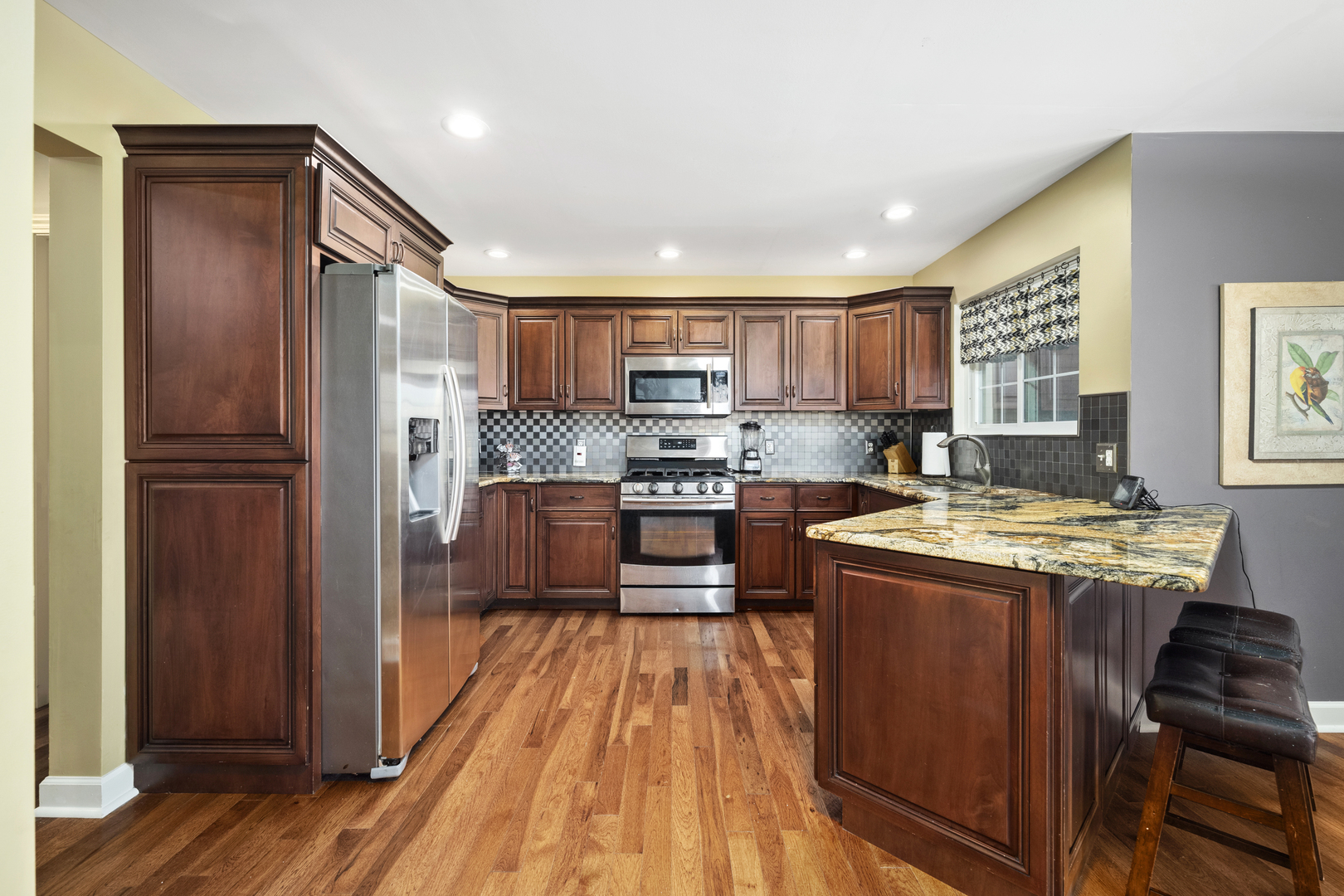 284 South Will Road Diamond, IL 60416 - Photo 9 of 23 a kitchen with kitchen island granite countertop wooden floors stainless steel appliances a sink and a window