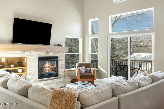 a living room with furniture a flat screen tv and a fireplace