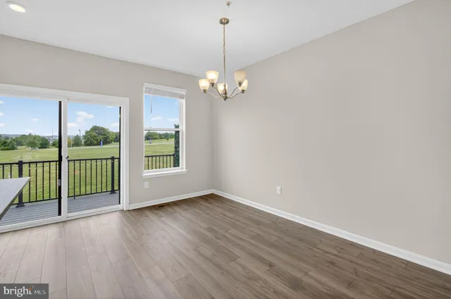 a view of a room with wooden floor fan and windows