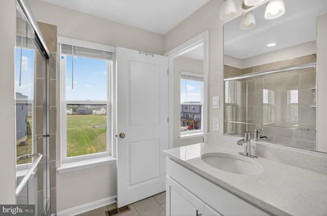 a bathroom with a granite countertop sink and a window