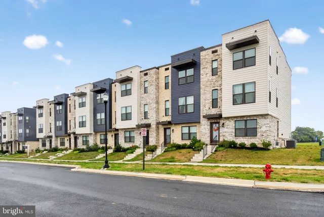 a view of building with a big yard and large trees