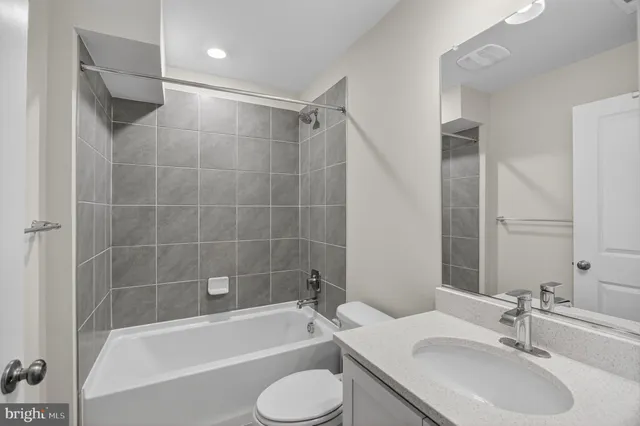 a bathroom with a granite countertop sink toilet tub and shower