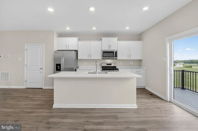 a large kitchen with stainless steel appliances a refrigerator and a stove top oven