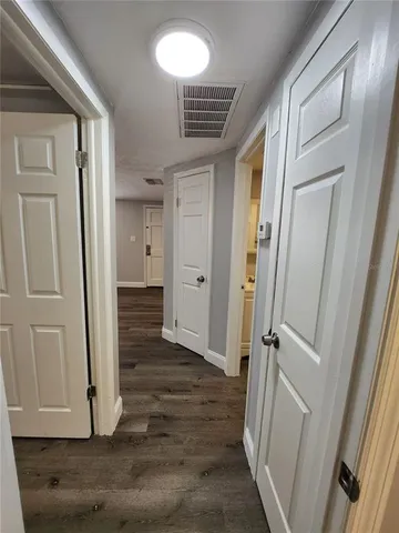 a view of a hallway with wooden floor and staircase