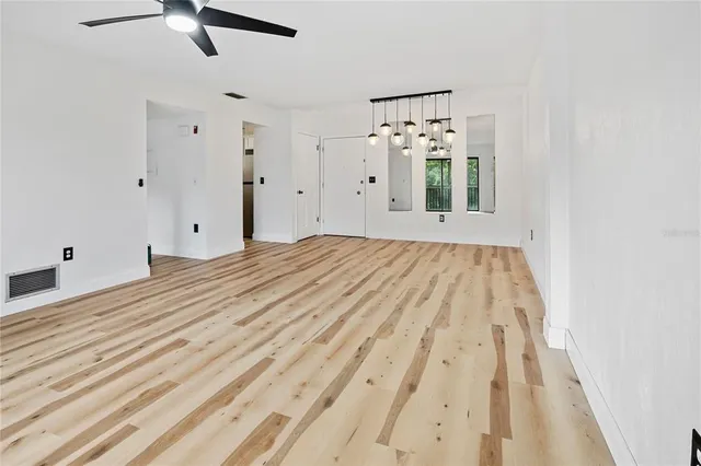 an empty room with window and a ceiling fan