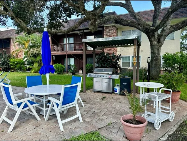 a view of a chairs and table in backyard of a house
