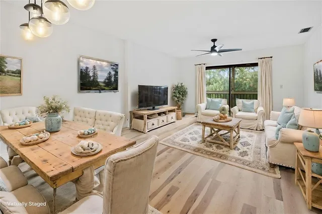 a living room with furniture a flat screen tv and a large window
