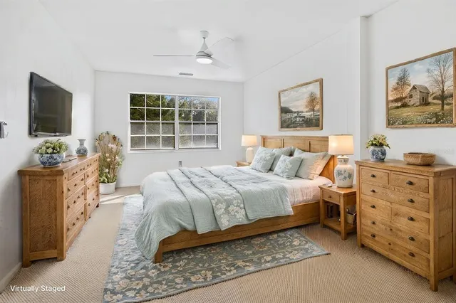 a spacious bedroom with a bed and a flat screen tv