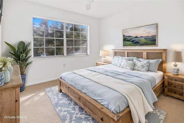 a bedroom with a large bed and a potted plant