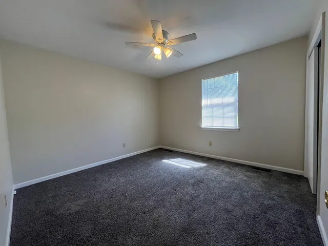 an empty room with a window and a ceiling fan