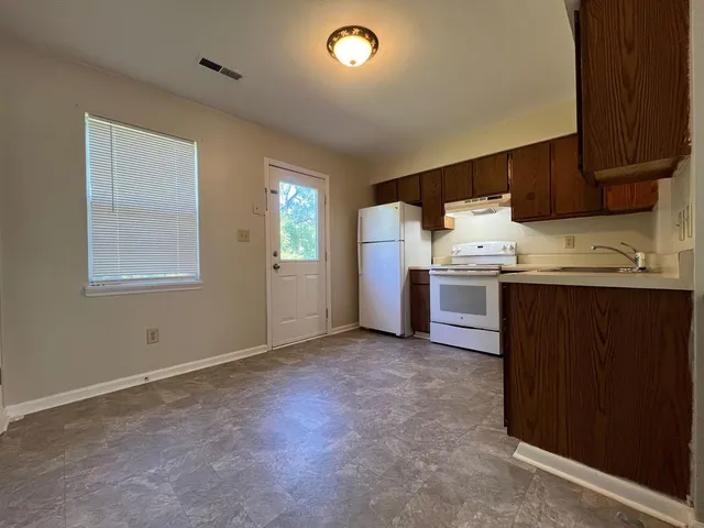 a kitchen with stainless steel appliances granite countertop a sink and a stove