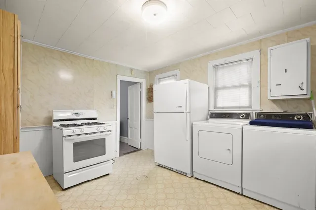 a kitchen with white cabinets and white appliances