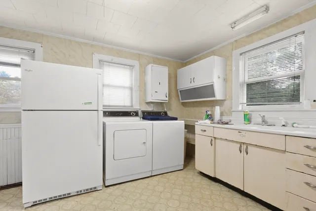 a kitchen with white cabinets white stainless steel appliances and sink