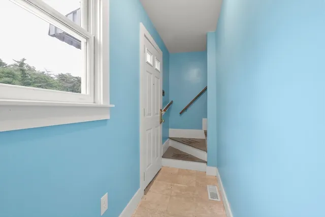 a view of a hallway with wooden floor and a window