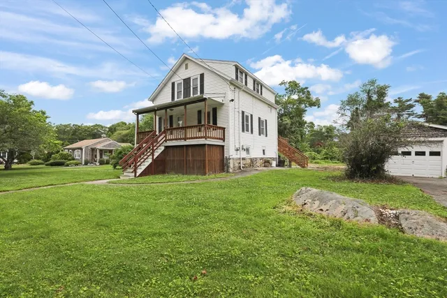 a view of a house with a big yard and large trees