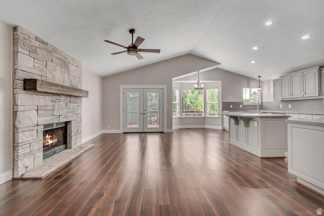 2154 Wasatch Boulevard Sandy, UT 84092 - Photo 20 of 55 Unfurnished living room with a ceiling fan, a fireplace, dark wood-style flooring, vaulted ceiling, and french doors