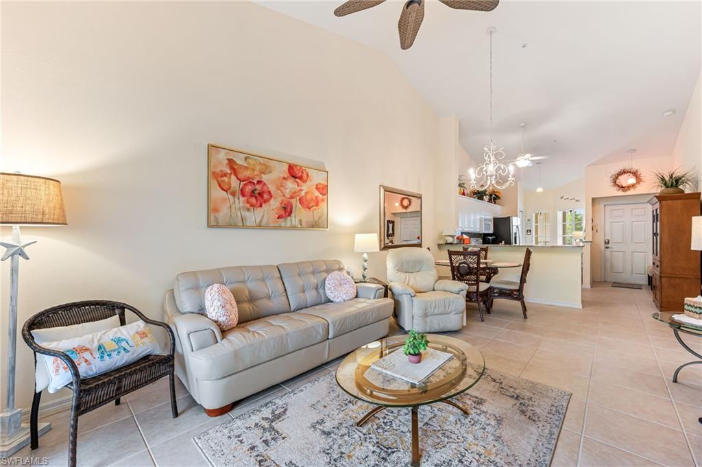 9185 Celeste Drive, Unit 305 Naples, FL 34113 - Photo 12 of 35 a living room with furniture a rug and a chandelier