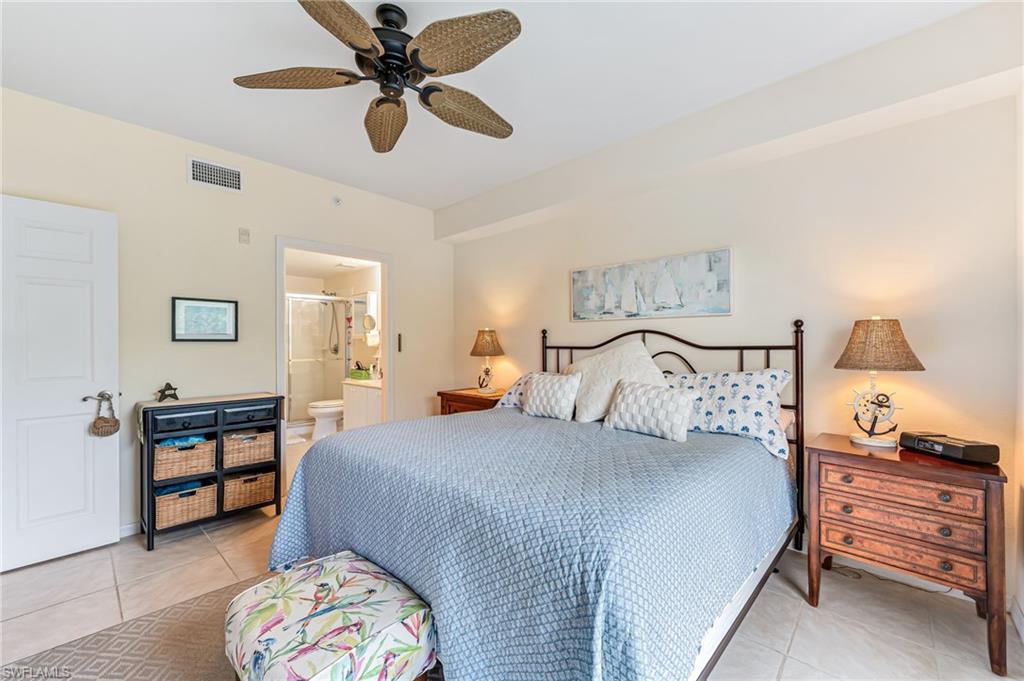 9185 Celeste Drive, Unit 305 Naples, FL 34113 - Photo 14 of 35 a bedroom with a bed and a chandelier fan