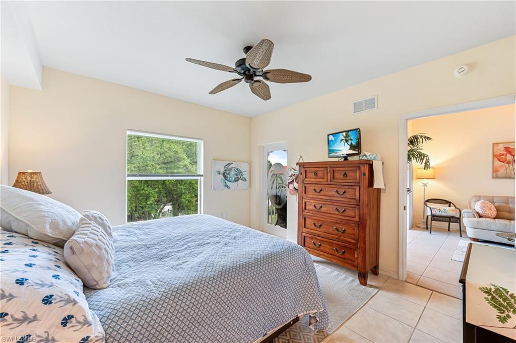 9185 Celeste Drive, Unit 305 Naples, FL 34113 - Photo 15 of 35 a bedroom with a bed a dresser and a window