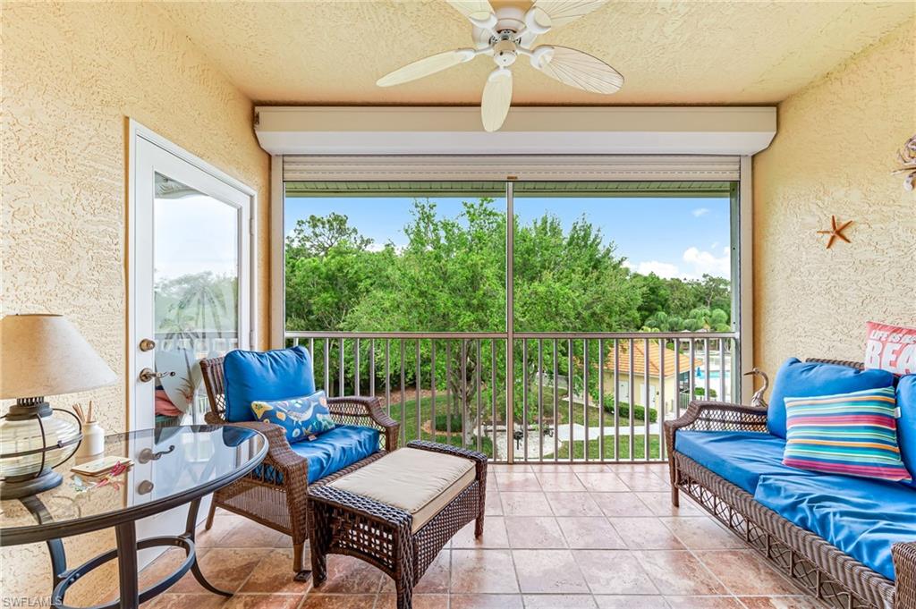 9185 Celeste Drive, Unit 305 Naples, FL 34113 - Photo 21 of 35 a living room with furniture and a floor to ceiling window