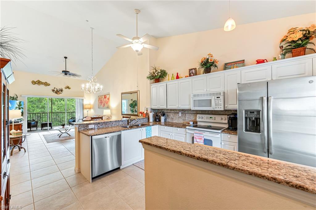 9185 Celeste Drive, Unit 305 Naples, FL 34113 - Photo 3 of 35 a large kitchen with stainless steel appliances kitchen island granite countertop a large counter top stainless steel appliances and cabinets