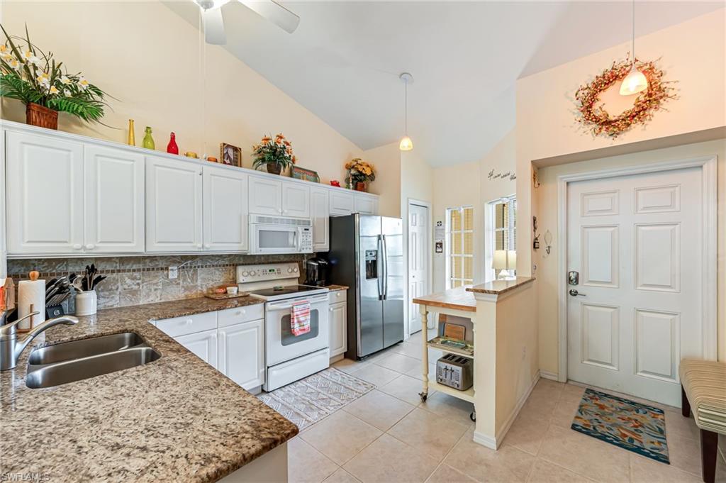 9185 Celeste Drive, Unit 305 Naples, FL 34113 - Photo 4 of 35 a kitchen with cabinets and wooden floor
