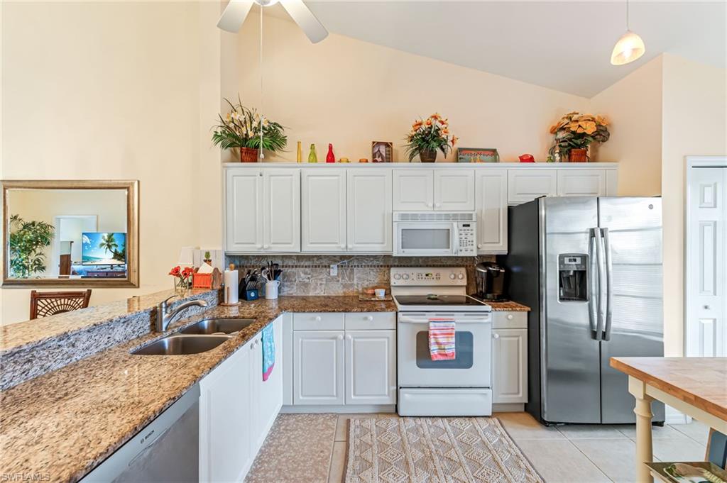 9185 Celeste Drive, Unit 305 Naples, FL 34113 - Photo 5 of 35 a kitchen with a sink dishwasher a refrigerator and a stove