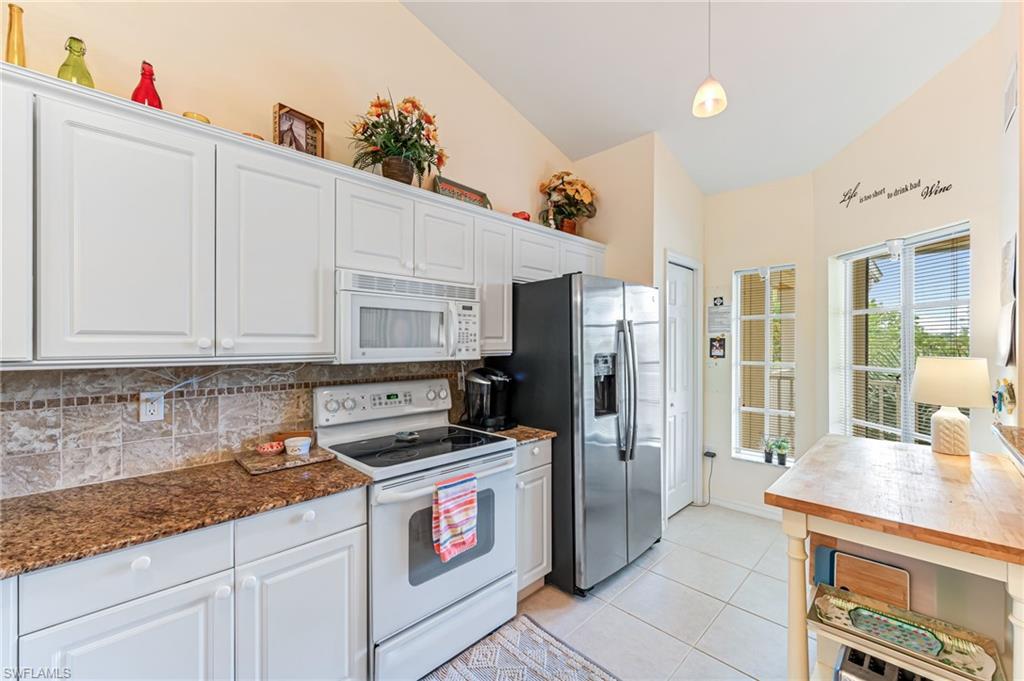 9185 Celeste Drive, Unit 305 Naples, FL 34113 - Photo 8 of 35 a kitchen with stainless steel appliances granite countertop a stove a sink and a refrigerator