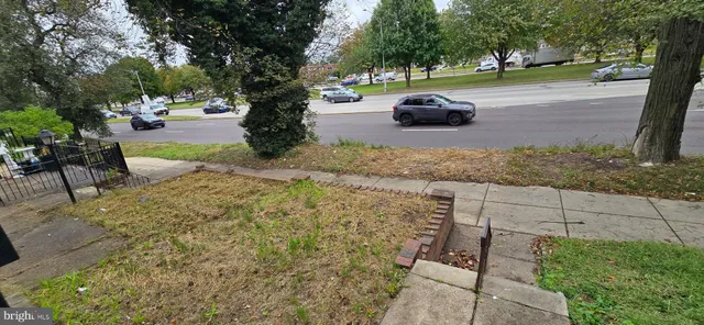 a view of a backyard with table and chairs plants and trees