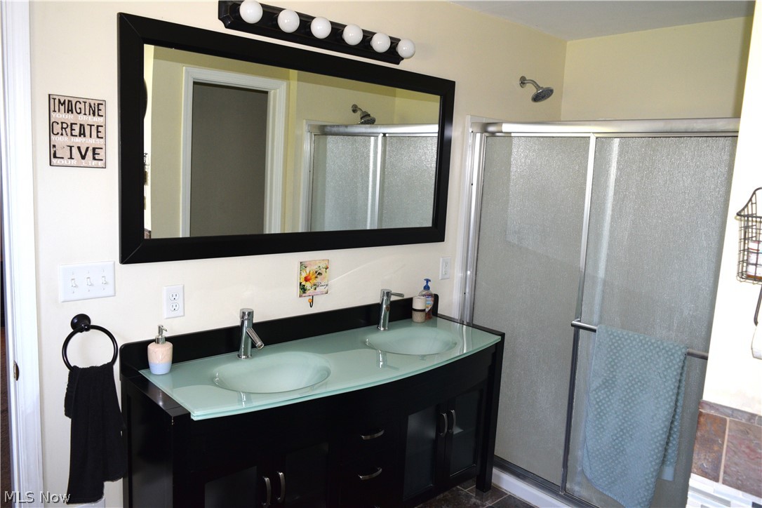 3285 Hemphill Road Barberton, OH 44203 - Photo 21 of 50 Bathroom with dual sinks, vanity with extensive cabinet space, tile floors, and a shower with shower door