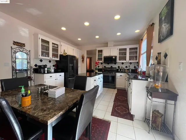 a kitchen with stainless steel appliances granite countertop sink stove refrigerator and cabinets