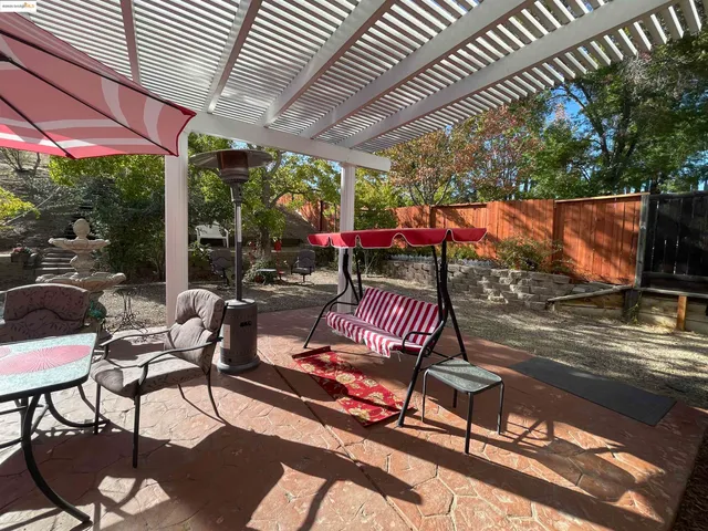 a view of a patio with a table and chairs under an umbrella
